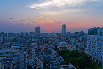 二つのビルの間に沈む赤い夕日