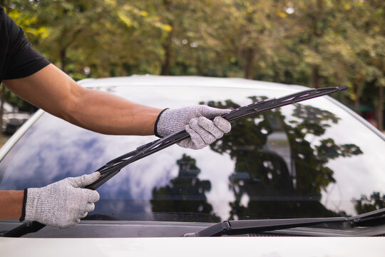 mechanic is checking car wiper blades to replace new wiper blades for car during the rainy season because when it rains it can be used at full efficiency. Checking and cleaning the car wiper blades