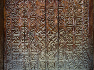 Closeup view of traditional wood carving on ancient door with intricate floral and geometric design, Namadgut, Ishkashim, Gorno-Badakhshan, Tajikistan