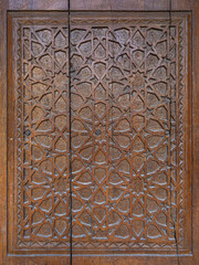 Closeup view of traditional wood carving on ancient door with intricate floral and geometric design, Hisor aka Hissar, Tajikistan