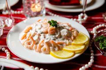 Festive fish table with Skagen salad - traditional Swedish starter dish with shrimps. Celebration delicacies on Christmas table in Finland and Scandinavia