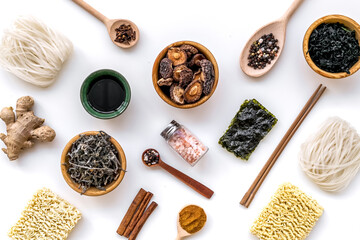 Chinese and Japanese food cooking with ginger, spices and noodles on white background top view geometric pattern