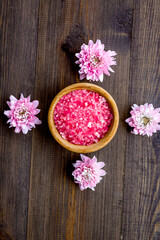 pink spa salt for aroma therapy with flower fragrance on wooden background top view