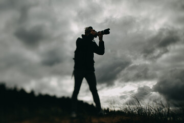 Silhouette of Photographer Against Dramatic Cloudy Sky