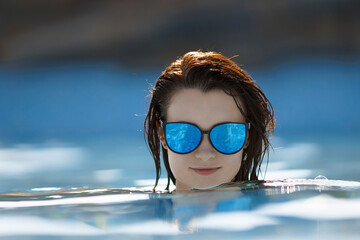Close up portrait of sensual glamour model getting in private pool, mirrored sunglasses.