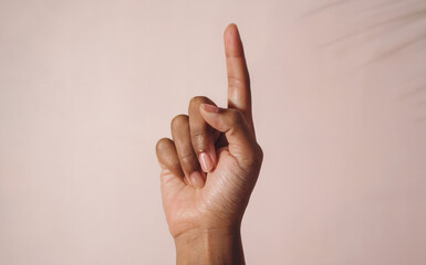 Index Finger Pointing Up Pose: An extreme close-up shot of a single hand with the index finger pointing upward, while the other fingers are folded