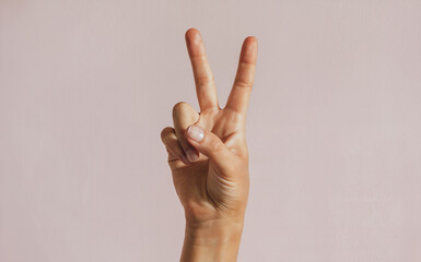 Peace Sign Pose: An extreme close-up shot of a single hand holding up a peace sign, with two fingers extended gracefully