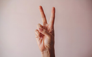 Peace Sign Pose: An extreme close-up shot of a single hand holding up a peace sign, with two fingers extended gracefully