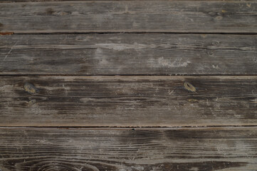 Naklejka premium Weathered wooden planks create a rustic, natural aesthetic on a tranquil outdoor deck in soft afternoon light