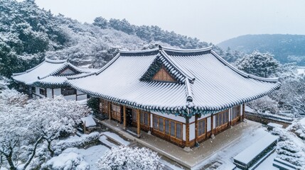 Fototapeta premium Snow-dusted roofs of a traditional temple in South Korea, capturing the peaceful December season