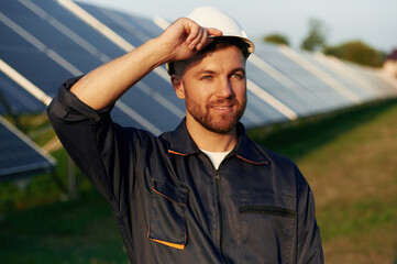 Handsome guy portrait. Man is working with solar panels outdoors at daytime