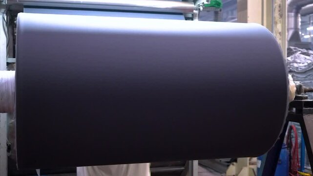Close up view of fabric manufacturing machine in a textile factory.