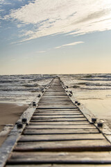 Obraz premium Long pier boardwalk leading out onto a Baltic sea, sunrise long way out