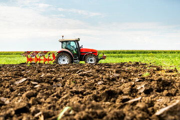 Agricultural tractor tilling fertile soil, readying the field for sowing