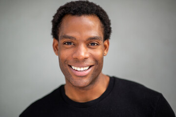 Man smiling directly at camera on gray background