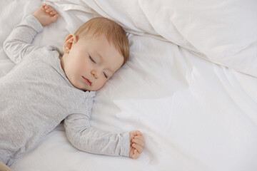 Cute little baby sleeping on bed at home, space for text