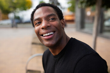 Man smiling and looking to the side in an outdoor setting