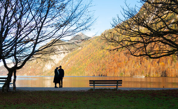 In autumn, Germany's K&ouml;nigssee becomes a tranquil mirror, reflecting fiery trees and mountains. At the lake's end lies the idyllic St. Bartholom&auml; Church, its red domes a striking contrast in the mist.