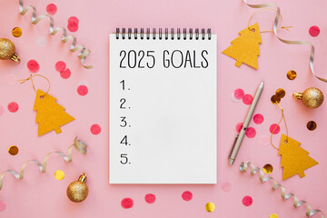 2025 goals list with notebook and pen on festive background. Resolutions, plan, goals, action,...