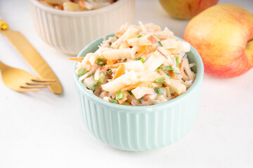 Asian Apple Slaw Salad with Apples, cabbage, carrot and spring onions. Healthy fall vegetable salad with yogurt dressing, in portioned bowls on kitchen table 