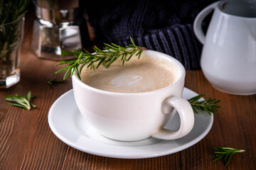 Cup of scented aromatic rosemary coffee latte, with whipped milk or cream