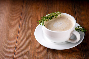 Cup of scented aromatic rosemary coffee latte, with whipped milk or cream