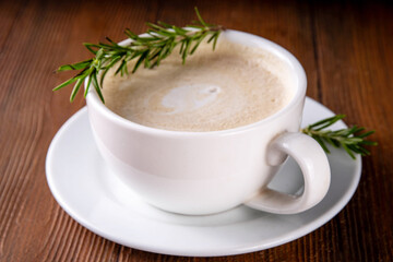 Cup of scented aromatic rosemary coffee latte, with whipped milk or cream