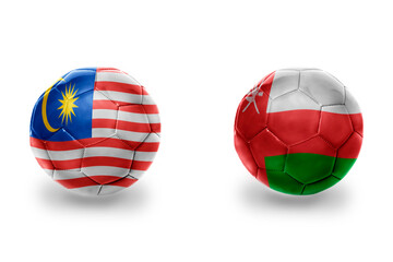 Obraz premium football balls with national flags of oman and malaysia ,soccer teams. on the white background.