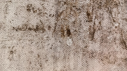 Detailed view of a rough, weathered surface featuring brown stains and irregular patterns, creating an abstract, aged appearance.