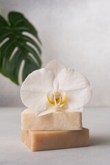 Elegant spa composition with natural soap bars and a white orchid flower.