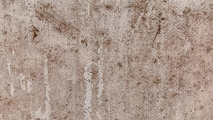 Detailed view of a rough, weathered surface featuring brown stains and irregular patterns, creating an abstract, aged appearance.