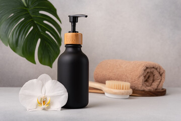Elegant black soap dispenser with bamboo cap in spa setting