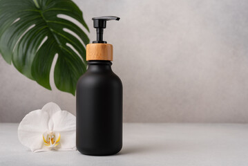 Elegant black soap dispenser with bamboo cap in spa setting