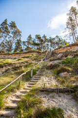 Sandy beach with a steep coastline and steep ladders stairs on the Baltic Sea