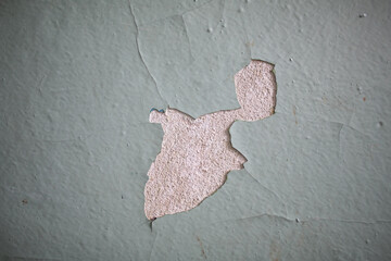 Cracked, peeling paint on the wall. A wall with old cracked blue paint. Patterns of cracks.