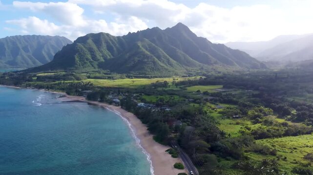 Incredible aerial view dramatic mountains blue ocean at Kualoa Ranch park, Punaluu beach park. Coast of Oahu island Hawaii USA. Beautiful nature view of green jungle mountain peaks with tropical beach