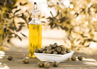 Green olives and oil on table in olive grove