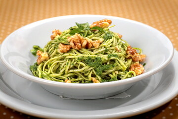 Capellini in Pesto sauce with walnuts on plate