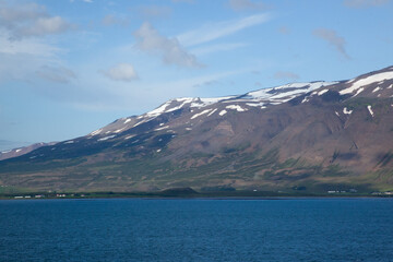 Iceland's mountains with snow at the ocean