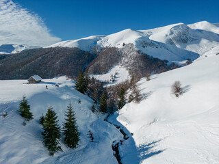 Fototapeta premium winter landscape with towering snow-capped peaks rising against a cloudless blue sky