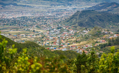 Panoramic view of a small town in Tenerife nestled in a valley surrounded by hills and greenery