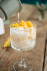 An ice cream bowl with coconut ice cream with mango sticky rice and coconut sauce