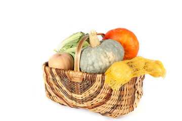 Autumn vegetables in a wicker basket on a white background: pumpkin, potatoes, cauliflower