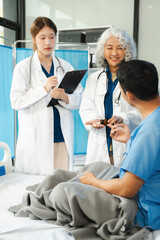 Obraz premium doctor talking to male patient at bed in hospital.