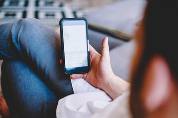 Man surfing on cellphone sitting on sofa