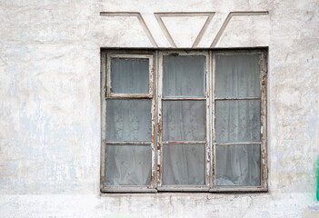 A window with three panes of glass and a curtain