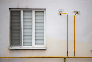 A window with a yellow pipe sticking out of it