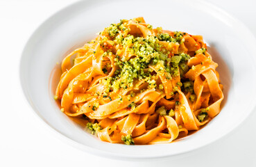 italian tagliatelle pasta with tomato sauce and basil parmesan on white. restaurant recipe