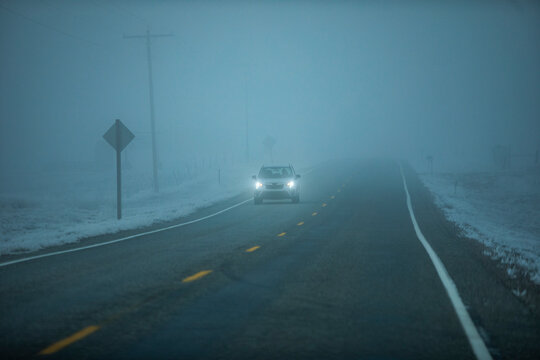 Car on Idaho 20 road in heavy fog at dusk