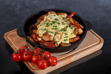 Stewed chicken, onions, potatoes and various vegetables in a cast iron skillet.